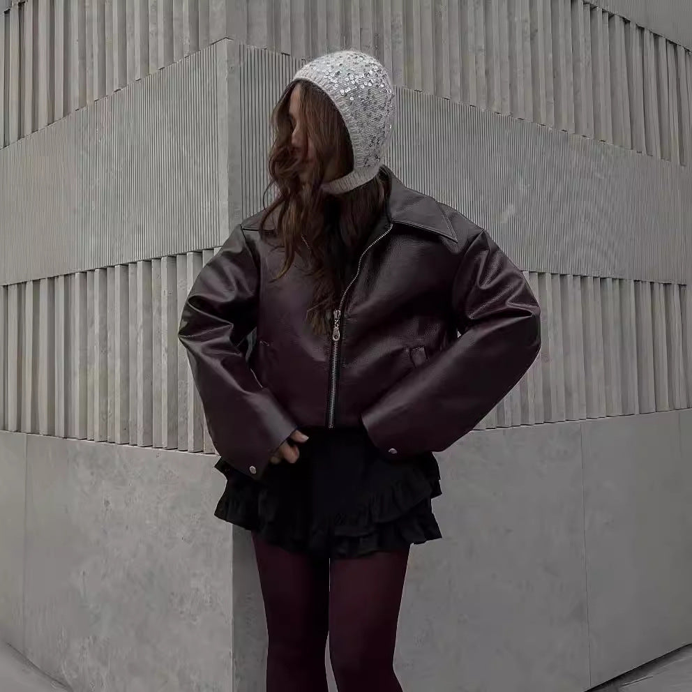 Kvinna i kort vinröd skinnjacka