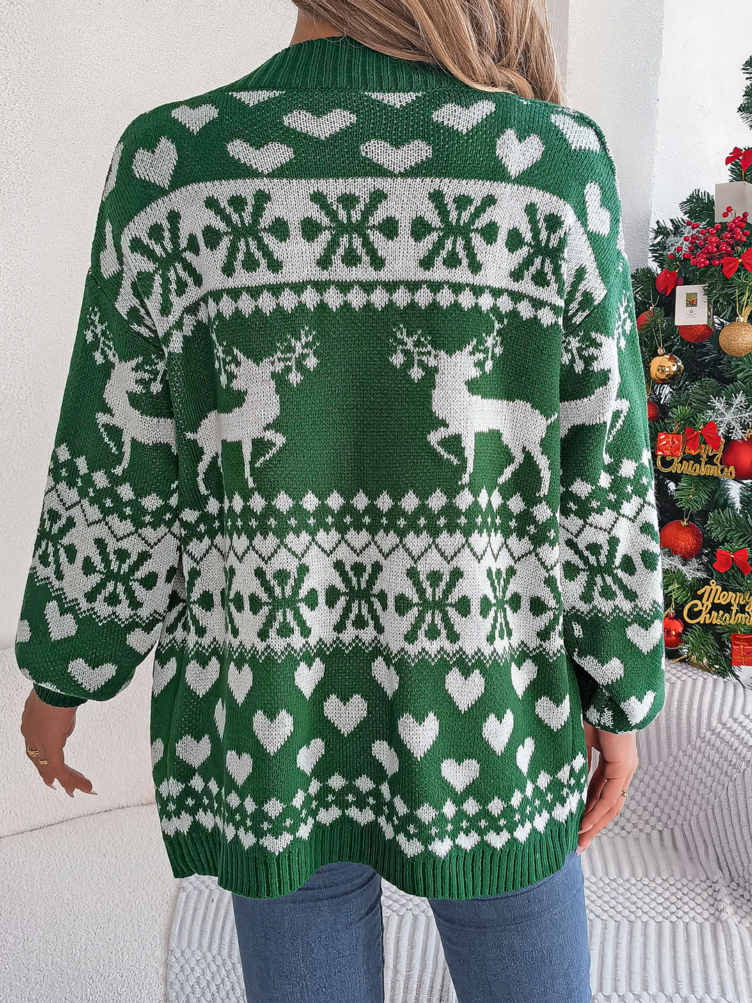 Kvinna i röd öppen julkofta med renar